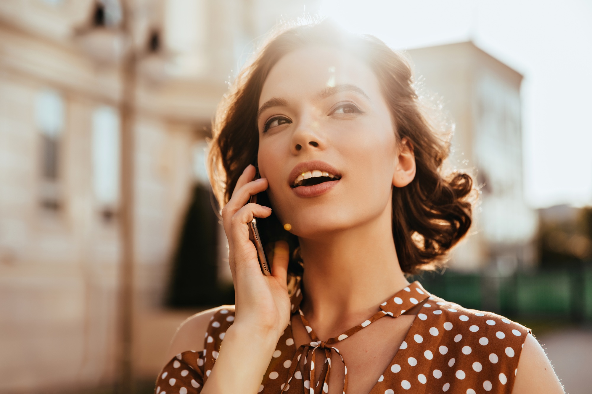 Adorable white woman calling someone while walking around town. Outdoor photo of dreamy caucasian g